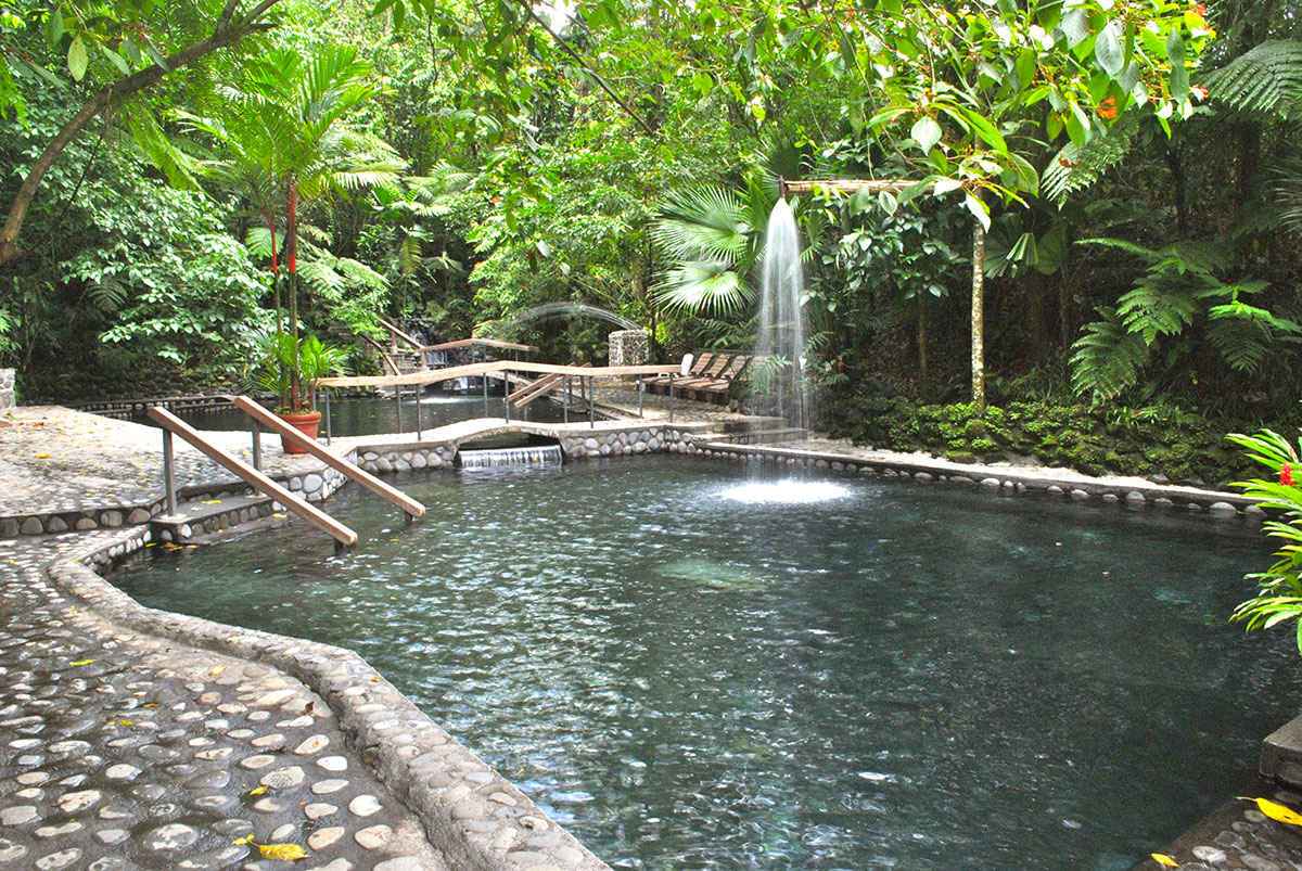 Stonework and foliage surround the pools of Eco Termales Hot Springs.