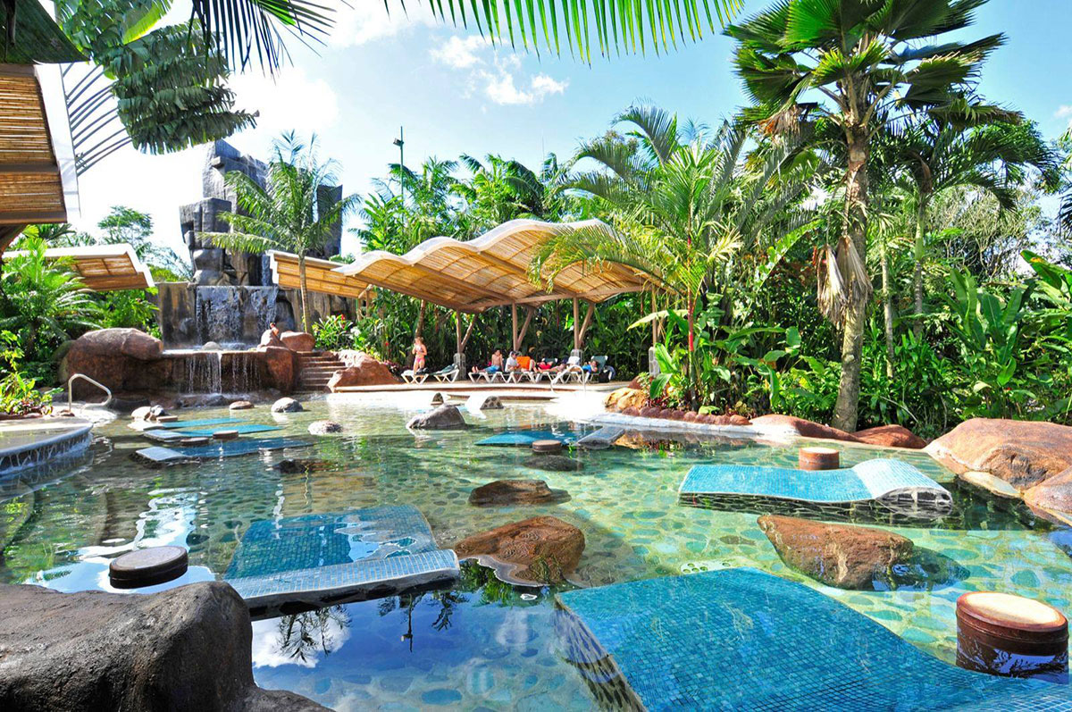 Emerald palm trees and luscious foliage surround a Baldi Hot Springs pool.